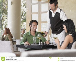 waiter-serving-wine-to-couple-young-outdoor-restaurant-31829407