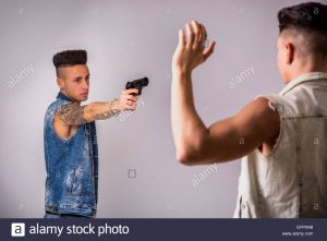 young-man-pointing-a-gun-to-another-guy-EFP0HB